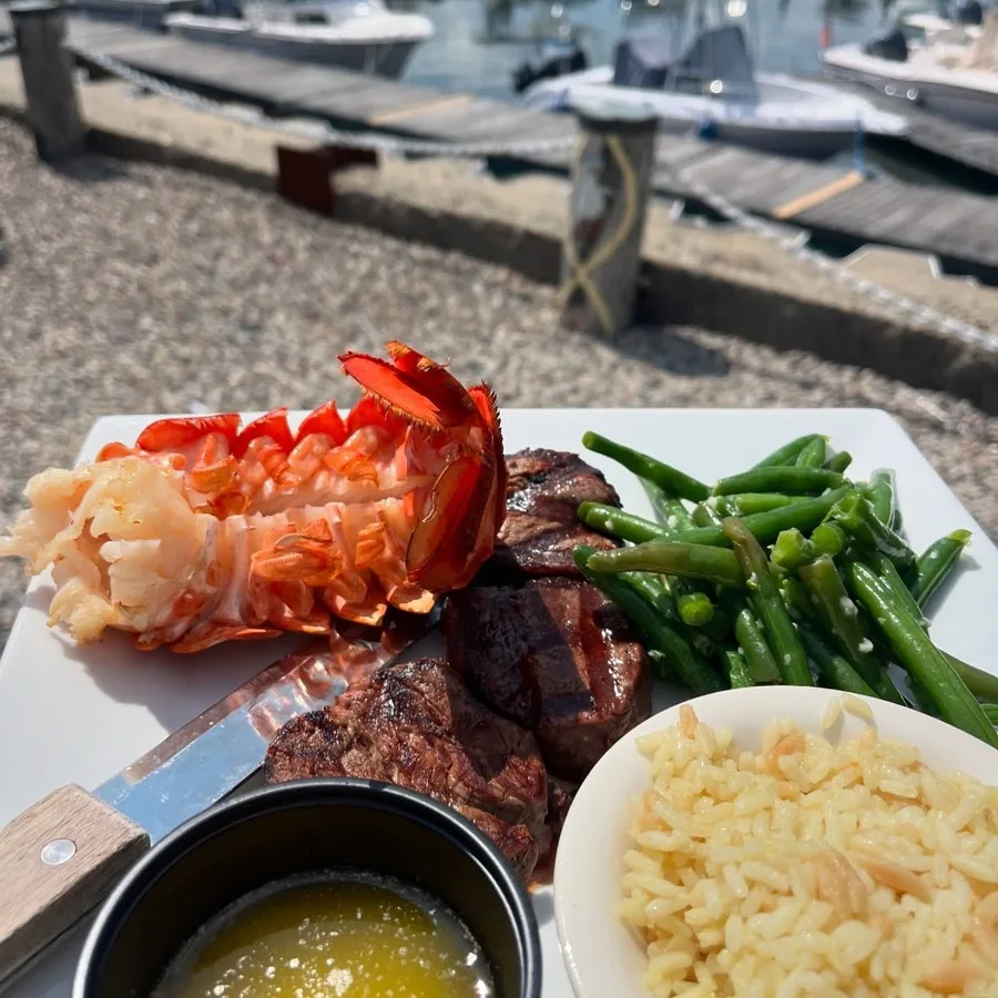 Lobster tail and steak tip dinner plate overlooking Taylor Marina